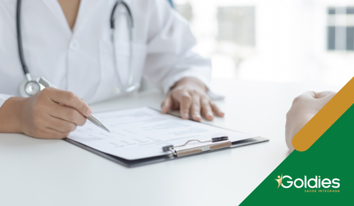 Médico preenchendo um prontuário, ilustrando o post "Em 2023, mantenha as consultas dos seus pais ao geriatra regulares"