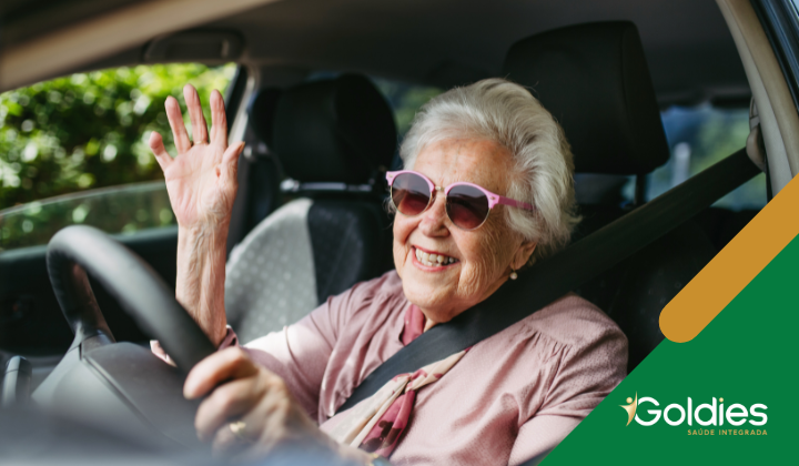 Senhora acena alegremente dirigindo seu carro, ilustrando o post "Como se adaptar às mudanças da vida na terceira idade"