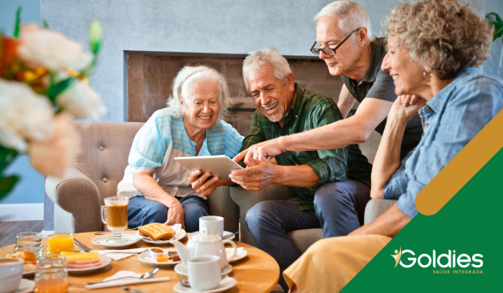 Grupo de idosos em atividade conjunta ao redor de uma mesa de café, ilustrando o artigo "Mantendo-se Socialmente Ativo na Terceira Idade: Benefícios e Dicas"